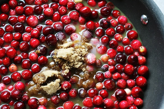 fresh cranberries sauce cooking in a pan with brown sugar